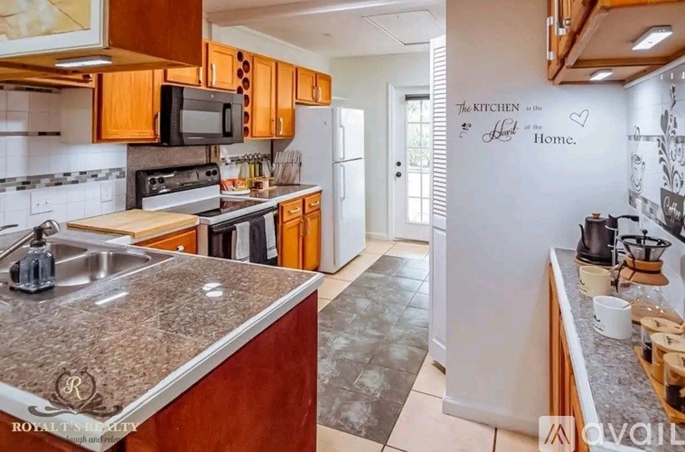 A kitchen with granite countertops and wooden cabinets.