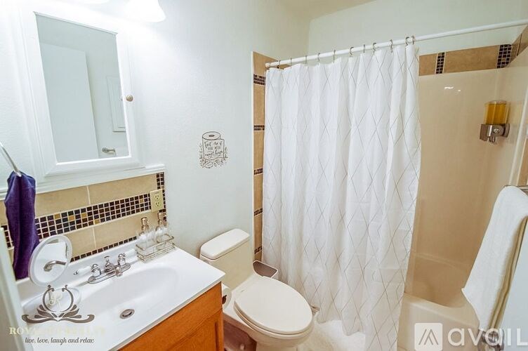 A white bathroom with a toilet, sink, and shower.