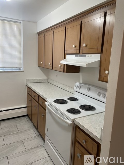 A kitchen with a white stove and wooden cabinets.
