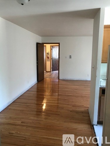 A hallway with wooden floors and a door at the end.