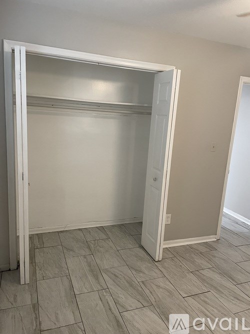 A white closet with a sliding door is open.
