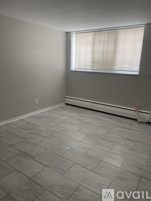 A room with a window and a tiled floor.