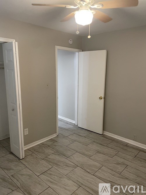 A room with a ceiling fan and tile flooring.