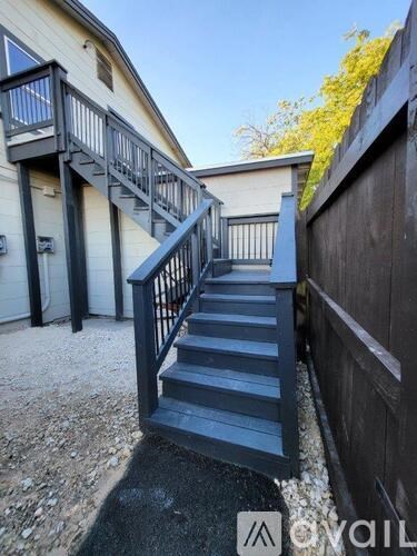 A set of stairs with a metal railing leads up to a building.