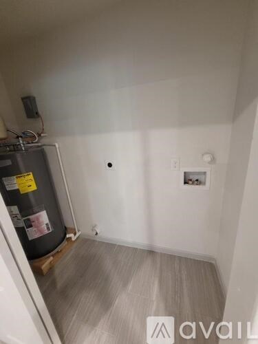 A small room with a fridge and a wall socket.