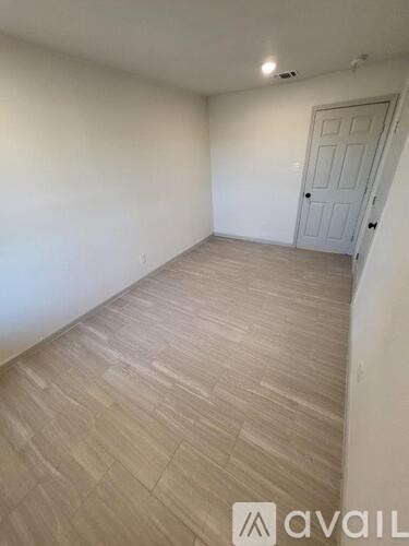 A room with a wooden floor and a white door.