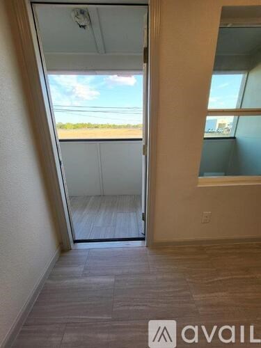 A room with a view of the outdoors through a glass door.
