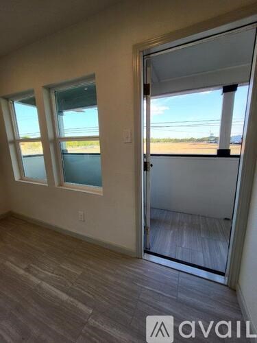 A room with a sliding glass door leading to a balcony.