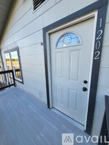 A white door with a glass window and a number 1202 on the side.
