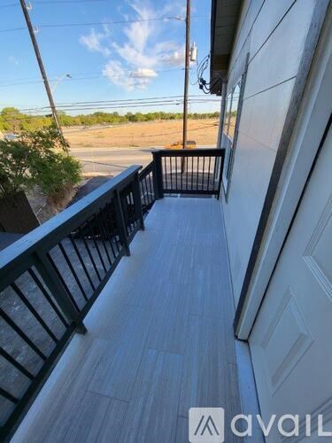 A balcony with a black railing and a wooden floor.