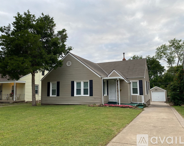 A house with a grey roof and a white door is for sale.