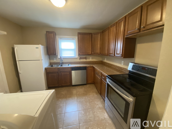 A kitchen with brown cabinets and black appliances.
