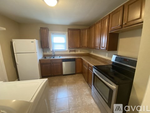 A kitchen with brown cabinets and black appliances.