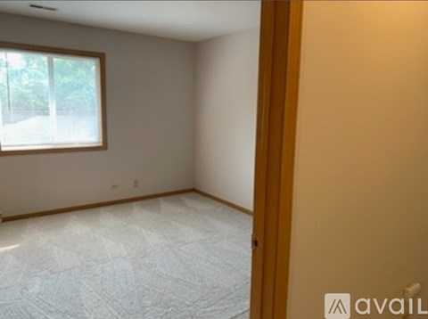 A room with a window and a carpeted floor.