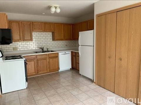 A kitchen with wooden cabinets and white appliances.
