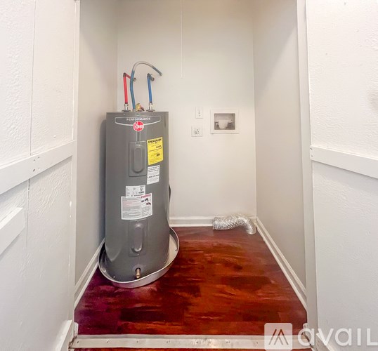 A water heater is installed in a room with white walls.