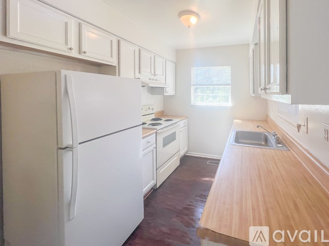 A kitchen with white appliances and wooden countertops.