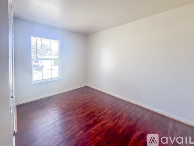 A room with a wooden floor and a window.