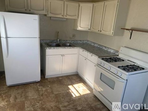 A kitchen with a white fridge, white oven, and white cabinets.