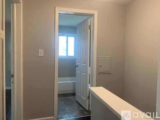 A white door is open to a room with a window.