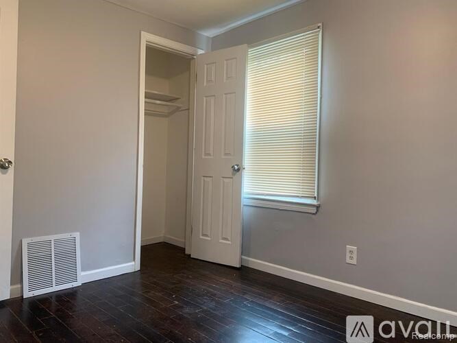 A room with a white door and a window with blinds.