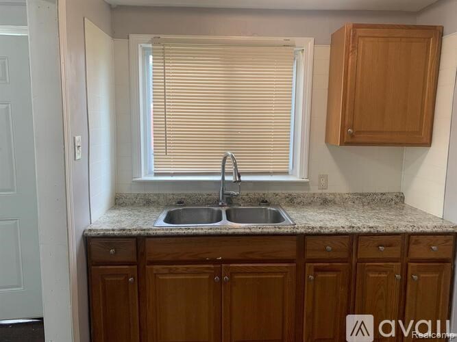 A kitchen with wooden cabinets and a granite countertop.