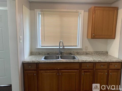 A kitchen with wooden cabinets and a granite countertop.