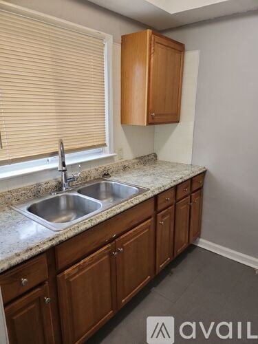 A kitchen with wooden cabinets and a granite countertop.