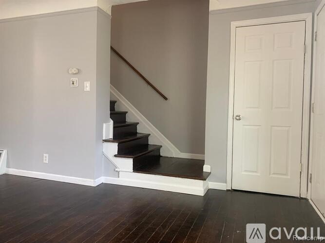 A room with a staircase and a white door.