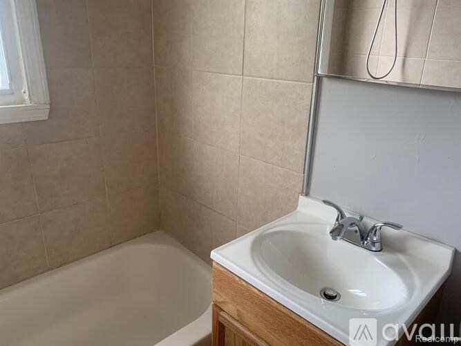 A bathroom with a white sink and a bathtub.