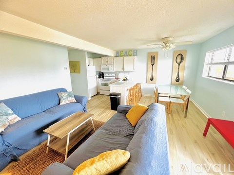 A living room with a couch, chairs, and a dining table.