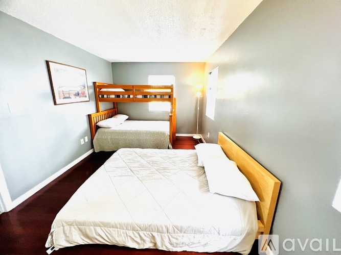 A bedroom with two beds and a single bed.