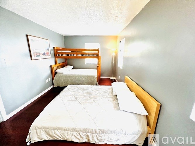 A bedroom with two beds and a single bed.