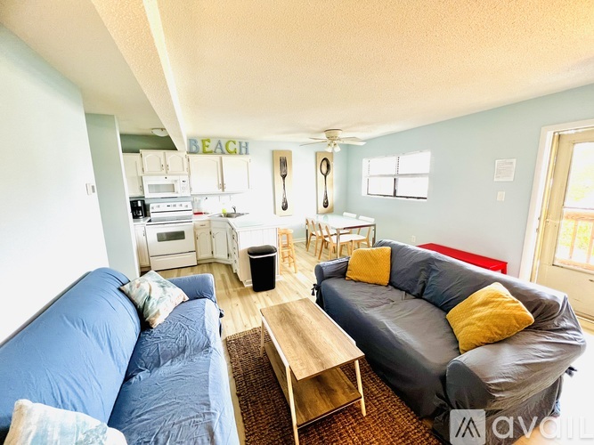 A living room with a blue couch and a grey couch.