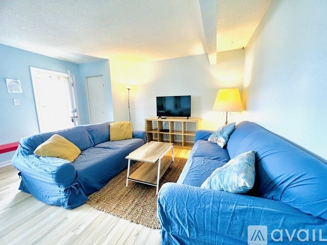 A living room with blue couches and a television.