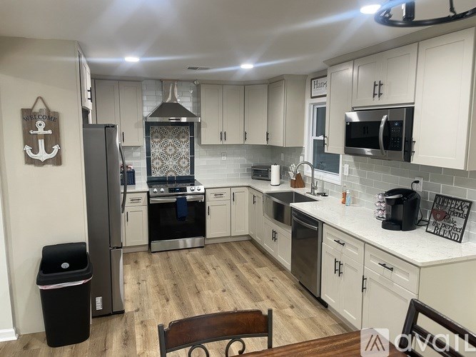 A kitchen with a black fridge and a wooden table.