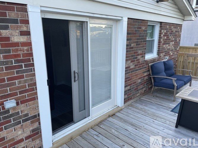 A patio with a sliding glass door and a blue chair.