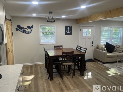 A dining room with a wooden table and chairs.