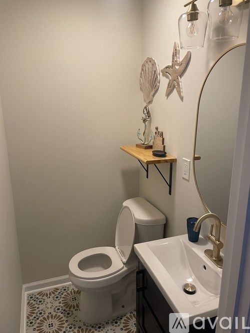 A bathroom with a toilet, sink, and decorative items.