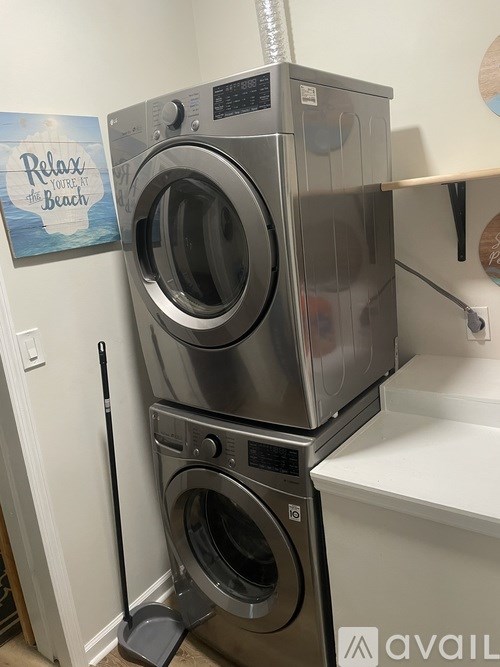 A stack of two washing machines in a laundry room.