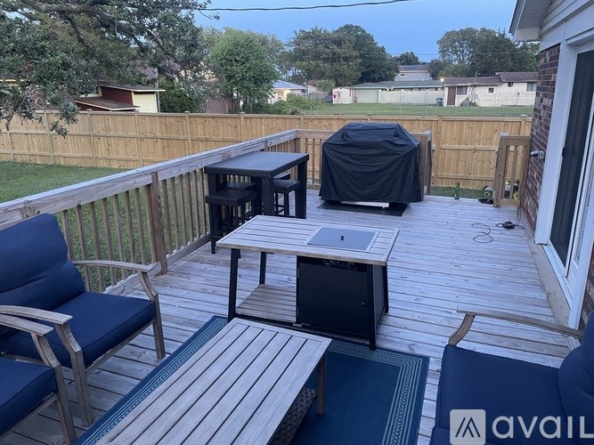 A patio with a table, chairs and a grill.