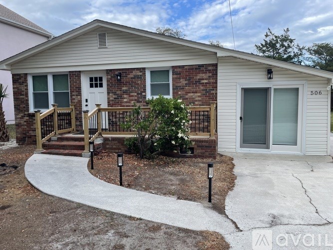 A house with a white front door and a brick wall.