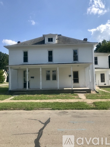 A white two-story house with a large front porch.