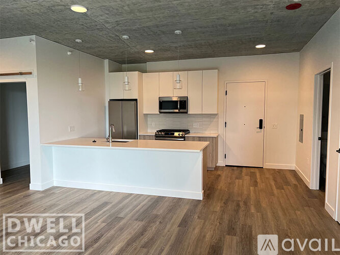 A kitchen with white cabinets and a wooden floor.