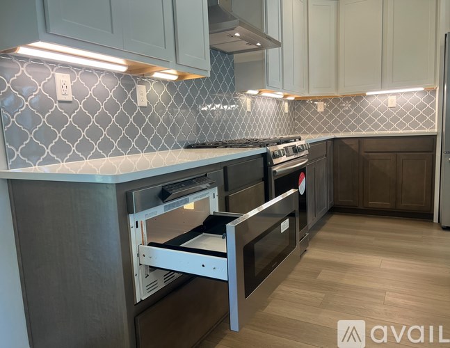 A kitchen with a tile backsplash and a stainless steel oven.