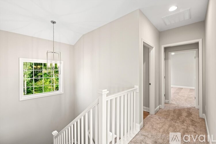 A white staircase with a railing leads to a second floor.