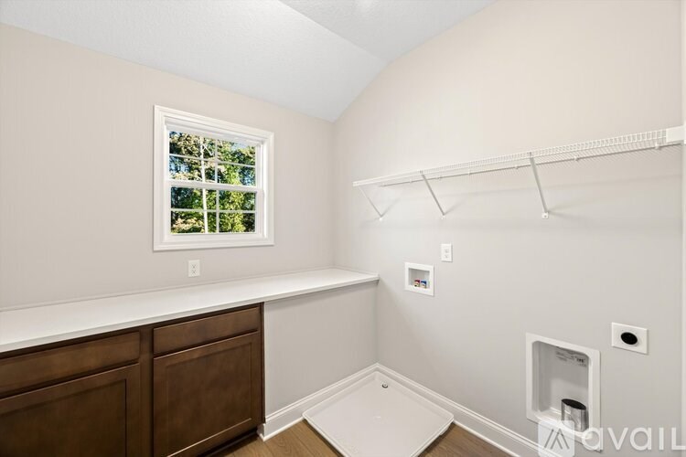 A room with a window, a shelf, and a cabinet.