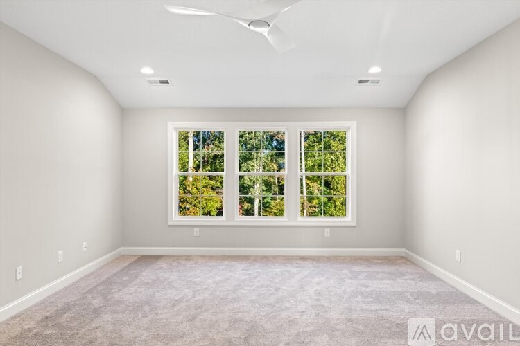 A room with a large window and a fan on the ceiling.
