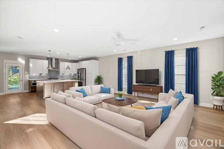 A modern living room with a large white sofa and a television.