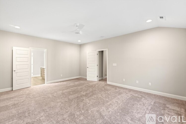 A spacious room with carpeted floor and two doors.